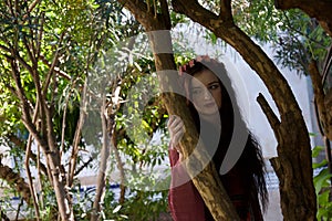 Sad hippie girl leaning against tree