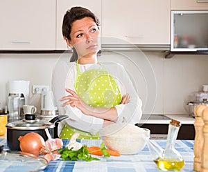 Sad housewife cooking dinner