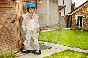 Sad hoverboard boy in overprotective bubble wrap