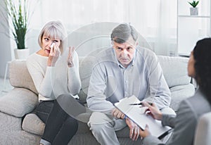 Sad husband and wife talking to psychotherapist