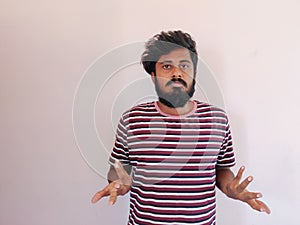 Sad Indian beard man, showing helpless gesture with arm and hands, mouth curved as if he does not know what to do. Isolated on