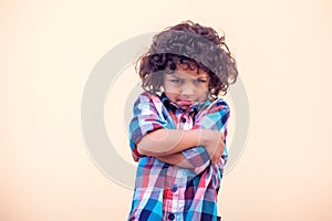 Sad kid with curly hair over isolated background