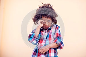 Sad kid with curly hair over isolated background