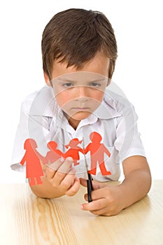 Sad kid cutting up paper people family