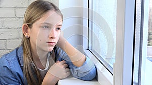 Sad Kid Looking on Window, Unhappy Child, Bored Thoughtful Girl, Teenager Face, Isolated People at Home in Coronavirus Crises photo