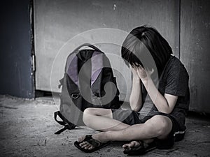 Sad Kid sitting on the floor with school bag waiting for parent.