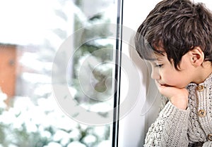 Sad kid on window cannot go out