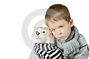 Sad little boy hugging toy dog isolated on the white