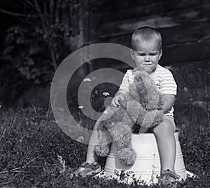 Sad little boy with teddy bear black and white