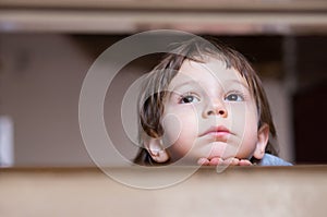 Sad little boy thinking looking up