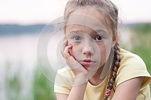 Sad little girl is crying and  looking with serious face at camera