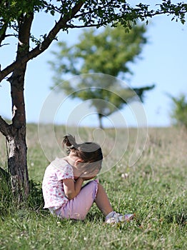 Sad little girl crying in nature