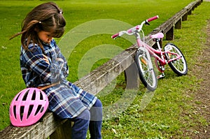 Sad little girl do not know how to ride a bike