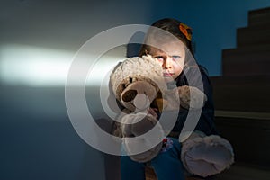 Sad little girl embracing her teddy bear - feels lonely