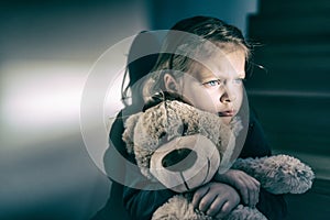 Sad little girl embracing her teddy bear - feels lonely