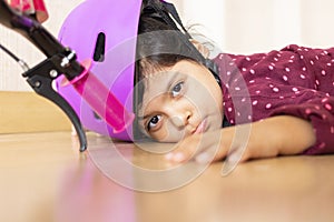 Sad little girl fell to the ground while playing with her bike