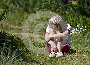 Sad little girl in garden