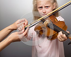 Sad little girl learns to play violin, upset, and unwillingness to learn