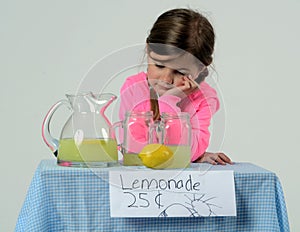 Sad little girl at lemonade stand in summer