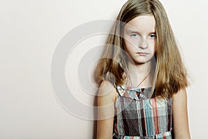 Sad little girl with long blond hair.