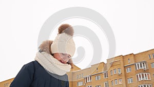 Sad little girl standing on street and looking down at wintertime