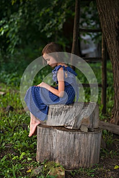 Sad little girl with tears on pretty face is crying and sitting alone