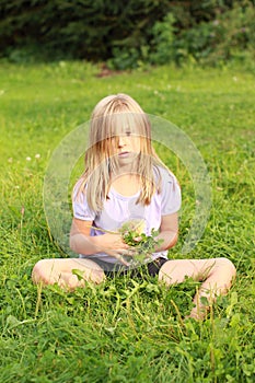 Sad little heary girl on grass