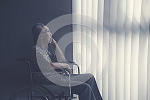 Sad lonely senior man sitting on wheelchair photo