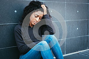 Sad and lonely teenager portrait in the city street