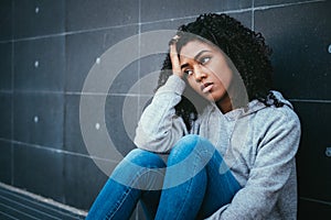 Sad and lonely teenager portrait in the city street