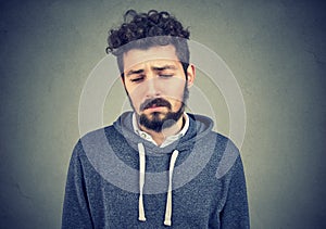 Sad lonely young man looking down has no energy motivation in life