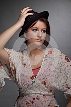 Sad looking brunette young woman with a hat