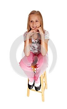 A sad looking young girl sitting on chair.