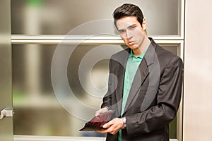 Sad looking young man showing empty wallet