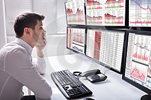 Sad Male Operator Looking At Graphs On Multiple Computer Screen