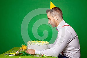 Sad man with birthday cake in studio