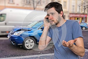 Sad man is calling to assistance after car accident