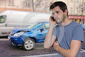 Sad man is calling to assistance after car accident