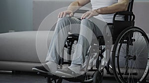 Sad man with disabilities sitting in wheelchair alone, suffering loneliness