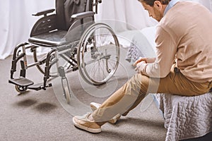 sad man with disability sitting on bed, wheelchair