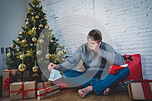 Sad man with face mask home alone at christmas missing family and friends