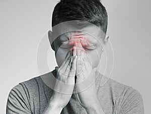 Sad man holding his nose because sinus pain