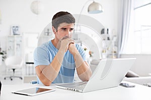 Sad man with a laptop at home. Freelance and selfemployment concept photo