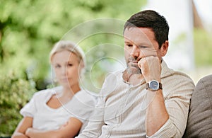 Sad man looking disappointed and ignoring wife after argument. Middle aged man thinking about divorce after fight and