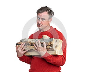 Sad man in a red sweater holds firewood in his hands, isolated on a white background.