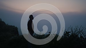 Sad man silhouette standing on mountain top. Lonely guy looking autumn landscape