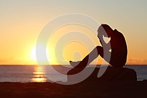 Smutný muž silueta ustarostený na pláž 