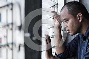 Sad man sitting in dark room. Depression and anxiety disorder concept