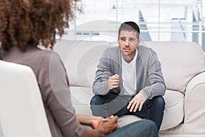 Sad man speaking to a therapist