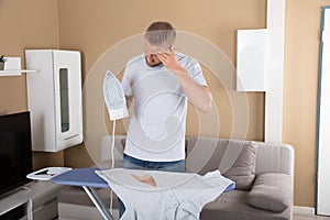 Sad Man Standing Near Iron Board Holding Iron